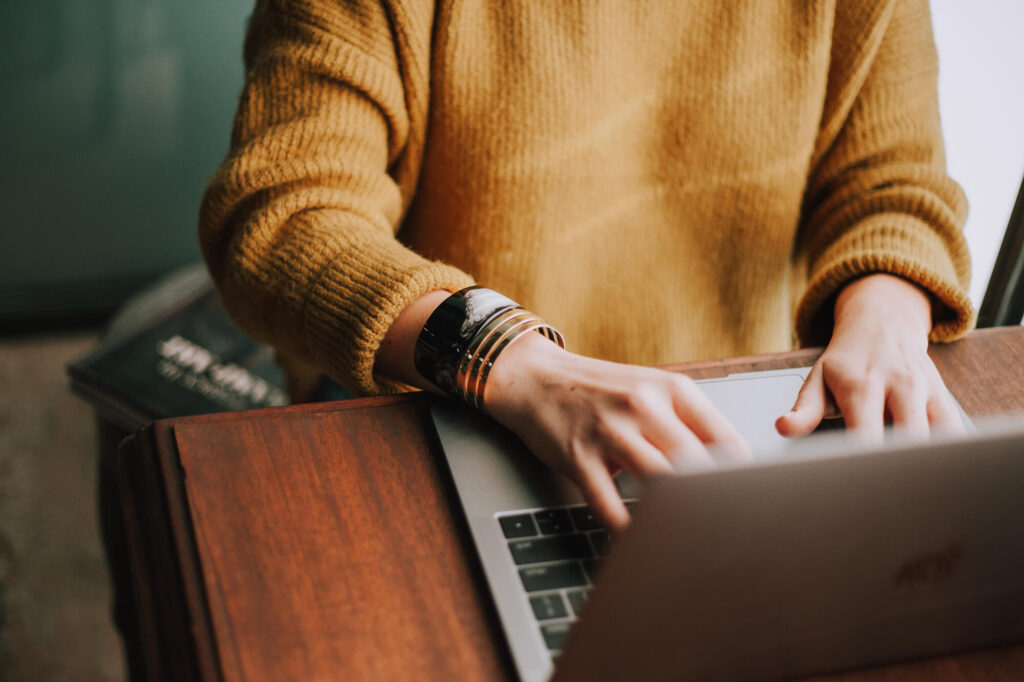 close up image of woman typing on laptop
